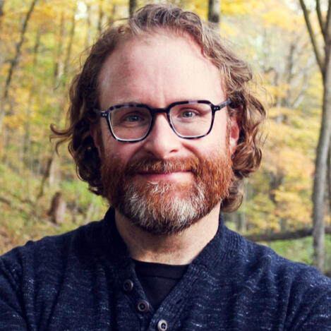 Josh Smith - Professional Voice Actor Headshot Josh Smith, professional voice actor, wearing a dark black sweater suit with a friendly expression.